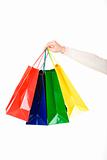 Woman hand carrying christmas shopping bags with gifts