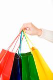 Woman hand carrying christmas shopping bags with gifts
