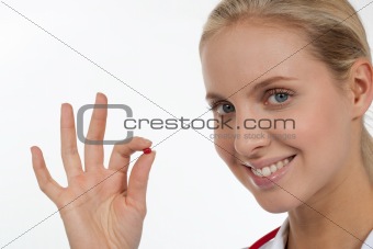 Doctor holding a small red pill in her fingers