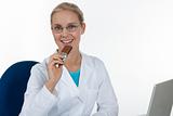 Beautiful female doctor eating chocolate while working in her of