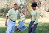 Playful African American Man, Woman and Child Having Fun in the Park.