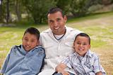 Hispanic Father and Sons Portrait in the Park.