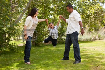 Hispanic Man, Woman and Child having fun in the park.