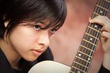 Attractive Ethnic Girl Enjoys Playing Her Guitar.