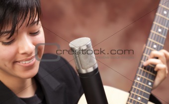 Attractive Ethnic Girl Enjoys Playing Her Guitar.