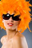 young pretty woman wearing an orange feather wig