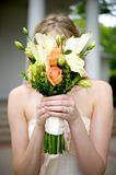 Bride Holding Bouquet Over Face