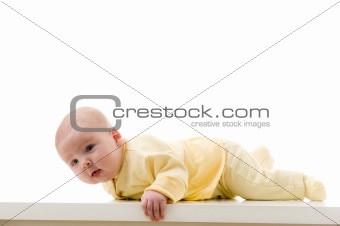 Young baby boy creeps on a table