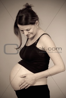 expecting woman - studio shot of a pregnant woman smiling