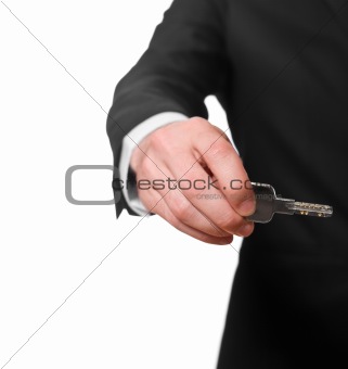 businessman in a black suit holding a key