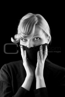 girl covers her mouth with a black turtleneck