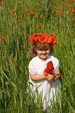 Little girl on wheat field with poppies