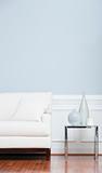 White Sofa and Glass End Table Against Blue Wall