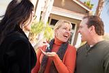 Hispanic Female Real Estate Agent Handing Over New House Keys to Excited Couple.