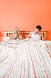 Young Couple Lying in Bed Laughing