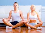 Young Couple Sitting on Floor Meditating