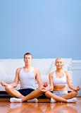 Young Couple Sitting on Floor Meditating