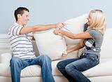 Young Couple Having a Pillow Fight on Sofa
