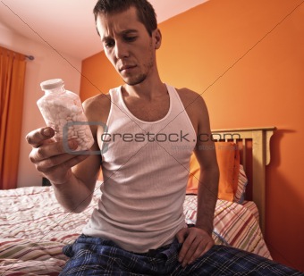Man Looking at Bottle of Pills