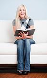 Happy Woman Sitting on Couch With Book