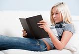 Smiling Woman Reading Book on Couch