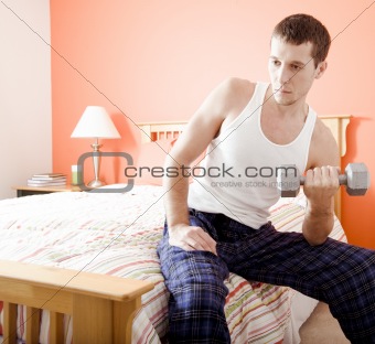 Man Using Arm Weight in Bedroom