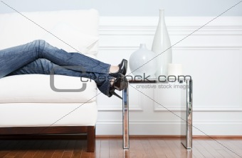 Woman's Leg's Reclining on White Couch
