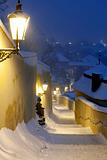 narrow stairway from hradcany castle with gas lanterns during heavy snowfall