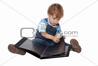 The boy looks on black pages in blue album