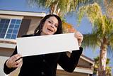 Happy Attractive Hispanic Woman Holding Blank Sign in Front of House.