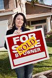 Happy Attractive Hispanic Woman Holding Sold For Sale By Owner Real Estate Sign In Front of House
