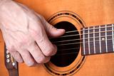closeup of hands of a musician playing acoustic guitar