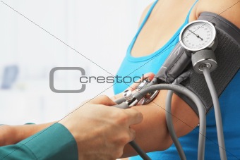 Checking blood pressure of female patient