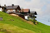 Alpine chalets on hill. Summer time