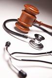 Gavel and Stethoscope on Gradated Background with Selective Focus.