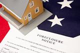 Foreclosure Notice and House on the American Flag with Selective Focus.