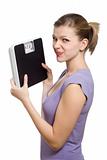 doubtful young woman holding a weight scale
