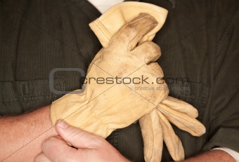 Man Putting on Leather Construction Gloves Close Up.