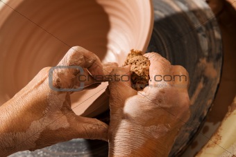 Hands forming pot on wheel