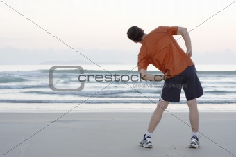Jogger doing stretching on a beach