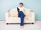 Young man sits comfortably on soft sofa