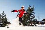female snowboarder over blue sky in forest 