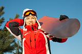 female snowboarder over blue sky in forest 