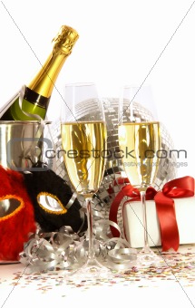 Glasses of champagne with mask and gift