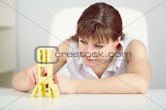 Girl is focused to build a tower with domino on table