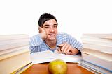 Young smiling male student sitting happy between study books