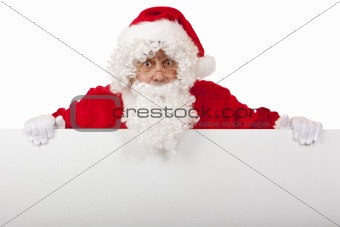 Surprised Santa Claus is holding a Christmas advertisment board 