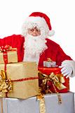 Surprised Santa Claus on knees with big stack of Christmas gift 