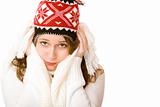 Young attractive freezing woman with cap and scarf holding her c