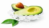 fresh avocado fruit with green leaves in glass dish